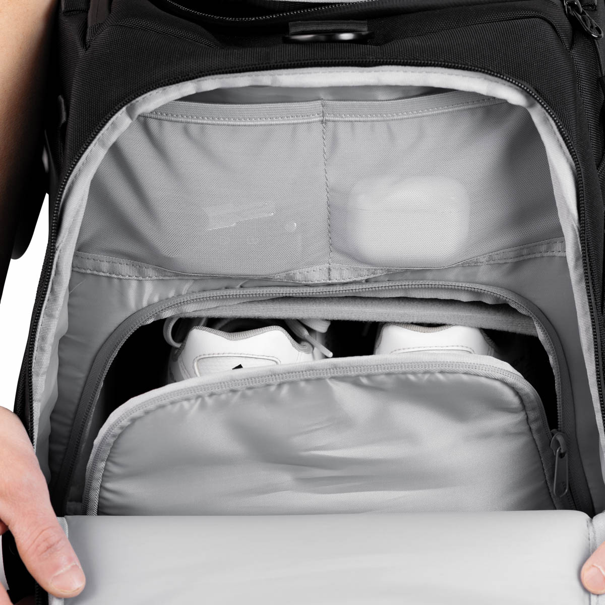 Nahaufnahme des Innenraums einer Zeeksack Duffelbag mit separatem Schuhfach und kleiner Netztasche mit Kopfhörern.
