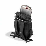 Schwarzer Rucksack von der Seite, steht auf dem Boden mit teilweise geöffnetem oberem Fach.