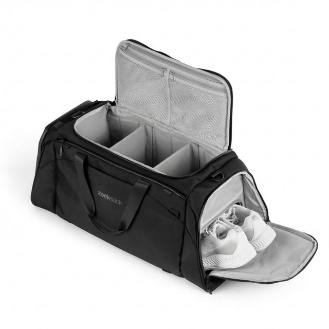 Schwarze Duffelbag mit organisierten Fächern und separatem Schuhfach mit weißen Schuhen.