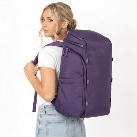 Frau mit lilafarbenem Rucksack auf dem Rücken.