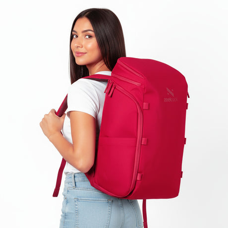 Frau mit rotem Rucksack auf dem Rücken.