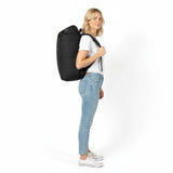 Frau im weißen T-Shirt und Jeans mit schwarzem Zeeksack-Rucksack, von der Seite gesehen.