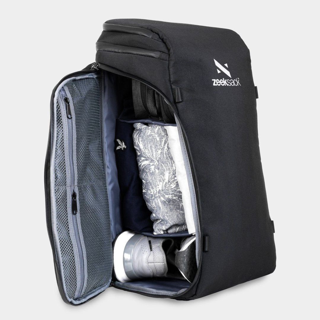 Ein schwarzer Rucksack, seitlich geöffnet und mit Schuhen und Kleidung gepackt.