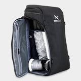 Ein schwarzer Rucksack, seitlich geöffnet und mit Schuhen und Kleidung gepackt.
