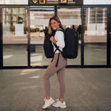 Zeeksack - Frau mit The Organizer 30L auf dem Rücken und The Underseat 15L vorne am Körper am Flughafen.