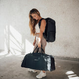 Zeeksack - Frau mit The Organizer 30L auf dem Rücken und The Weekender 50L in der Hand.