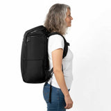 Ältere Frau trägt einen schwarzen Zeeksack Rucksack in seitlicher Ansicht, funktionaler Damenrucksack für Reisen und Alltag.