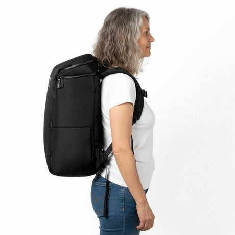 Ältere Frau trägt einen schwarzen Zeeksack Rucksack in seitlicher Ansicht, funktionaler Damenrucksack für Reisen und Alltag.