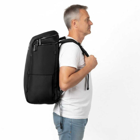 Älterer Mann trägt einen schwarzen Zeeksack Rucksack in seitlicher Ansicht, stilvoller und funktionaler Rucksack für Alltag und Reisen.
